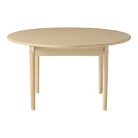 Round wooden table in a light beige finish with a smooth, minimalist design. Perfect for modern dining spaces.