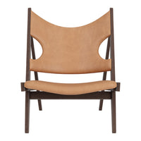 Tan leather chair with unique cut-out details and a dark wood frame, featuring a minimalist, modern design.