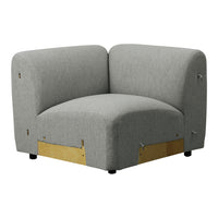 Gray upholstered corner chair with a smooth, minimalist design and subtle texture. Gold accents at the base.