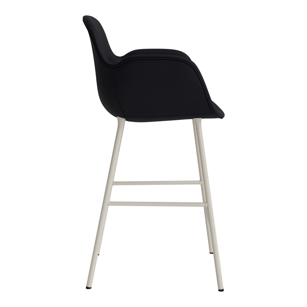 Black upholstered bar stool with sleek silver legs, featuring a minimalist design and smooth curves.