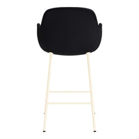 Black upholstered chair with cream legs, showcasing a sleek modern design and minimalistic style.