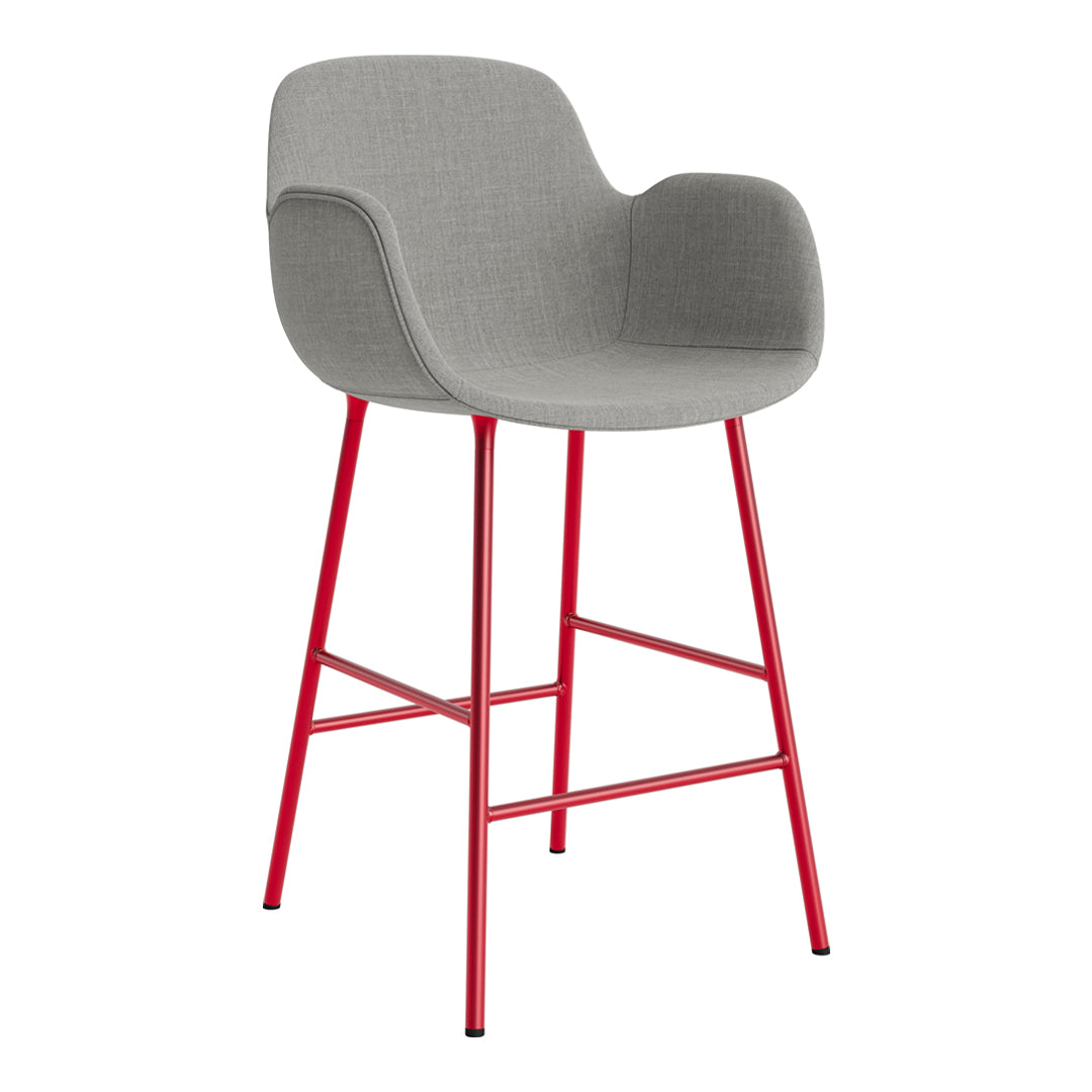 Gray upholstered bar stool with a sleek design and vibrant red metal legs. Modern and stylish accent for any space.