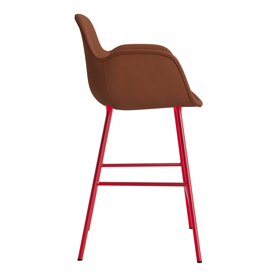 Brown upholstered bar stool with vibrant red metal legs, showcasing a modern and stylish design.