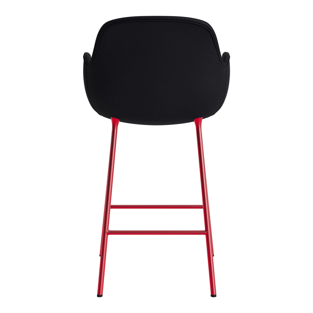 Black bar stool with a sleek, minimalist design and vibrant red legs, adding a pop of color to any space.