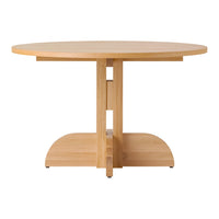 Round light wood dining table with a smooth finish and minimalist design, featuring a natural wood grain pattern.