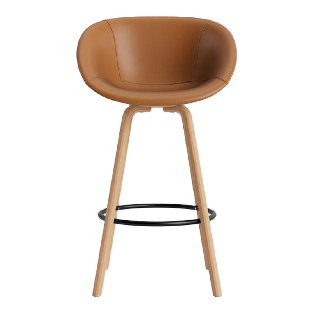 Tan leather bar stool with smooth curves and wooden legs, featuring a minimalist design and black footrest.