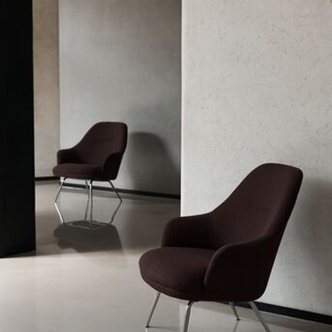 Sleek brown armchair with a smooth fabric, modern design, and chrome legs against a minimalist backdrop.