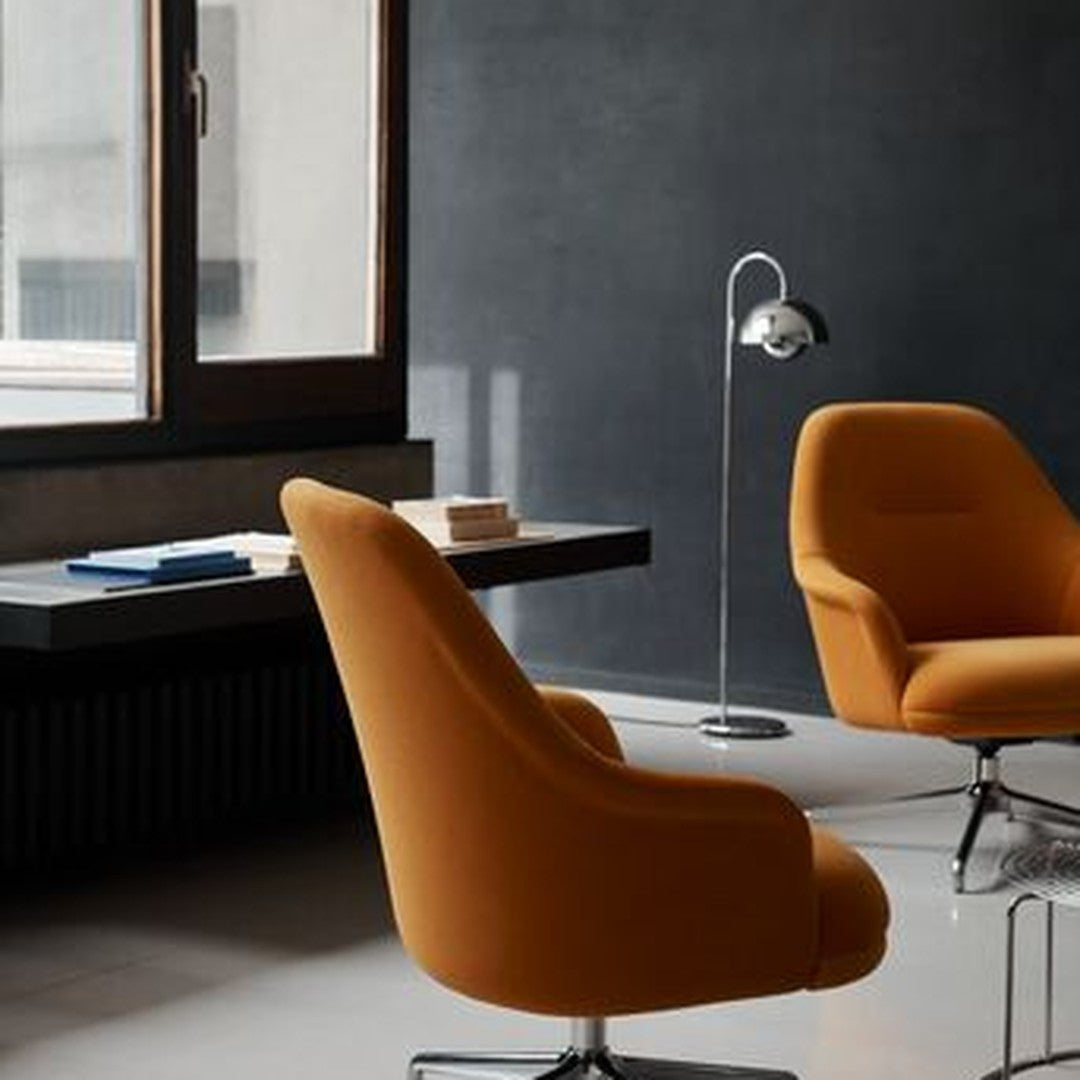 "Vibrant orange chairs in a modern space with a sleek black wall and minimalist decor."