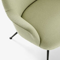 Soft green upholstery with a textured finish on a modern chair, featuring sleek black metal legs.