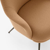 Curved chair in warm tan fabric with a textured pattern, featuring sleek black legs against a white background.