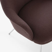 Dark brown upholstered chair with a smooth, curved design and sleek silver legs. Ideal modern accent piece.