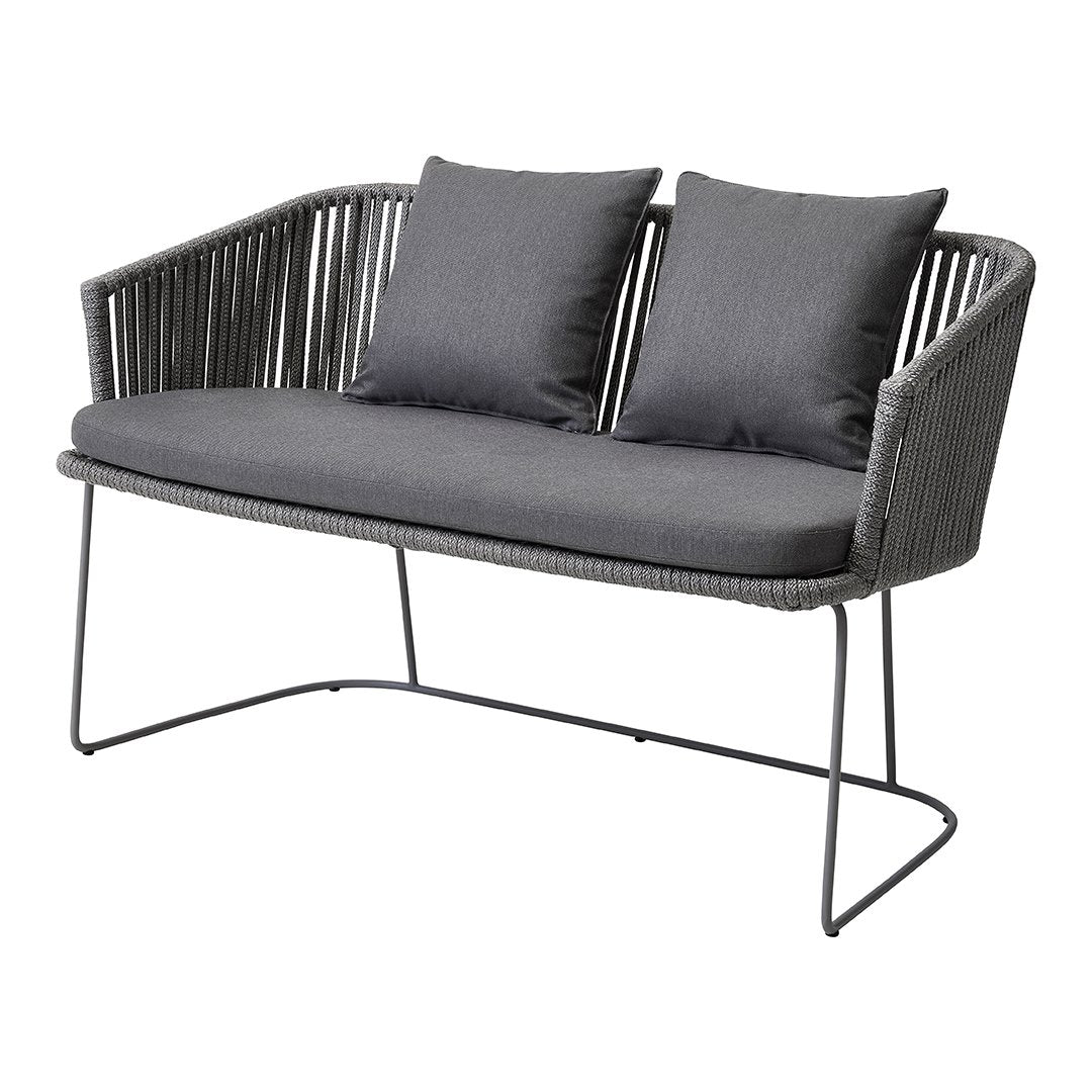 Gray woven loveseat with two matching cushions, featuring a sleek, modern design and minimalist metal legs.