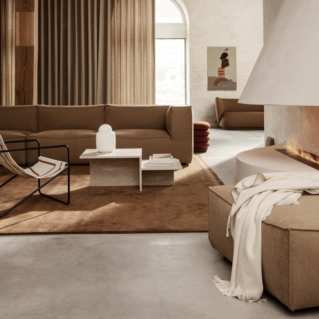 Modern living room featuring earthy brown tones, soft textures, and minimalist patterns for a cozy ambiance.