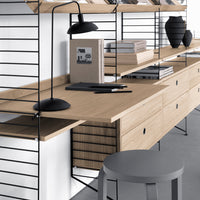 "Modern wooden desk with black metal accents, featuring a minimalistic design, neutral tones, and striped patterns."