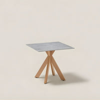 Square table with a gray marble top and natural wood tripod legs, featuring a modern minimalist design.
