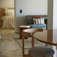 Modern living space featuring neutral tones, striped cushions, and geometric patterns in a cozy, inviting atmosphere.