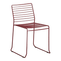 Red metal dining chair with sleek, minimalist design and horizontal slat pattern. Perfect for modern decor.