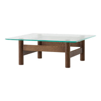 Square coffee table with a glass top and brown wooden legs, featuring a minimalist design and smooth surfaces.