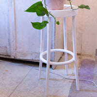 White stool with a minimalist design, featuring clean lines and a circular seat, perfect for modern decor.