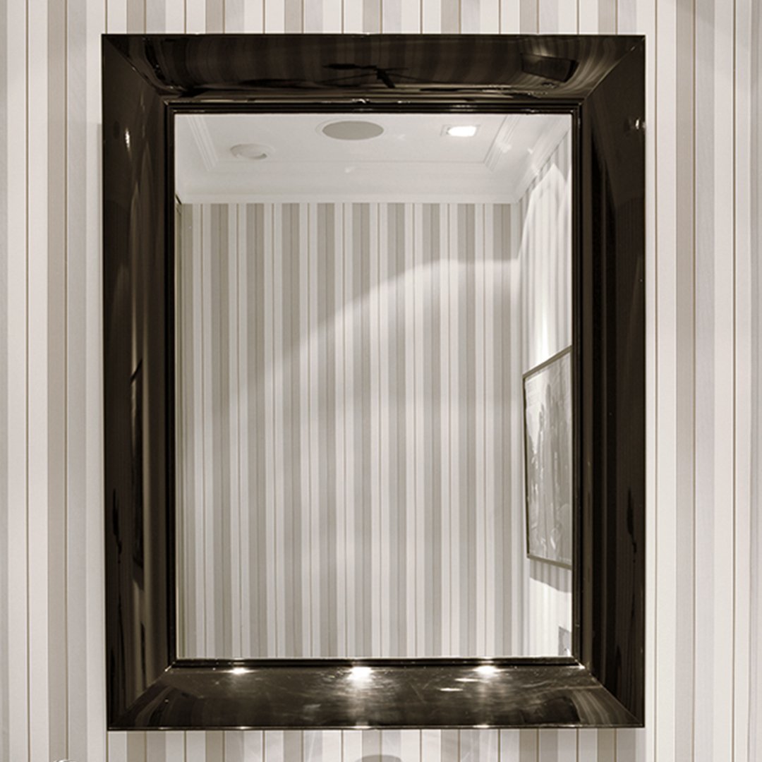 Black framed mirror reflecting sleek, vertical striped wall pattern in subtle tones of white and gray.