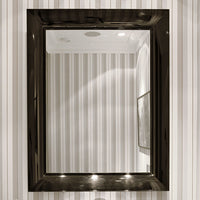 Black framed mirror reflecting sleek, vertical striped wall pattern in subtle tones of white and gray.