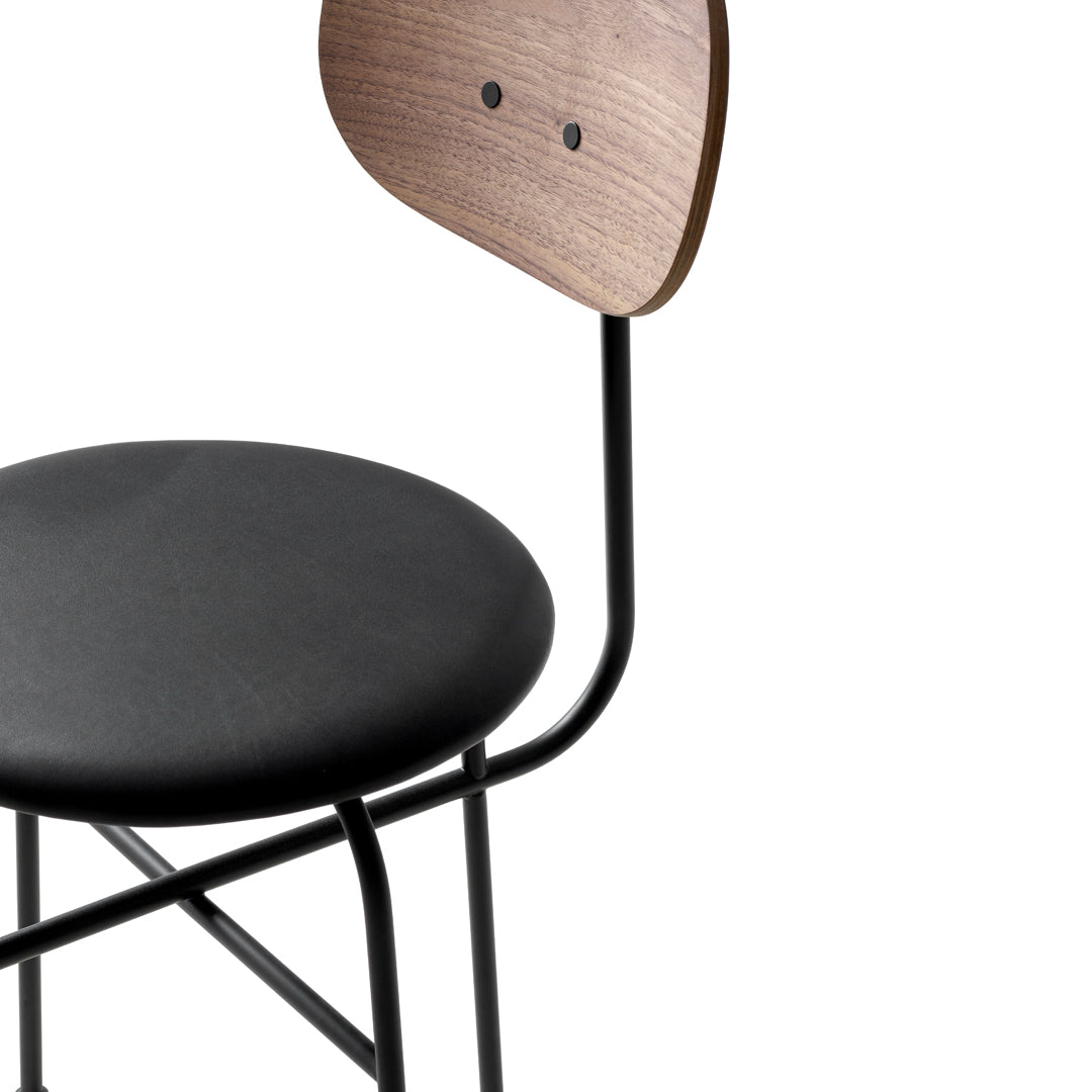 Black padded seat with a natural wood backrest and sleek black metal frame, showcasing modern minimalist design.