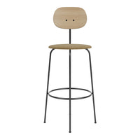 Wooden bar stool with a light oak seat and backrest, featuring a textured tan fabric on the seat and sleek black metal legs.