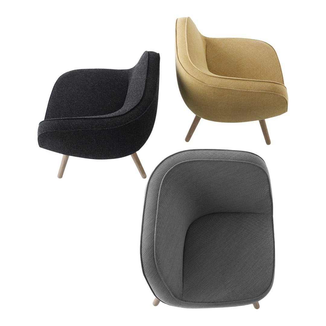 Three stylish chairs in charcoal, mustard yellow, and dark grey fabrics with smooth, modern shapes and wooden legs.