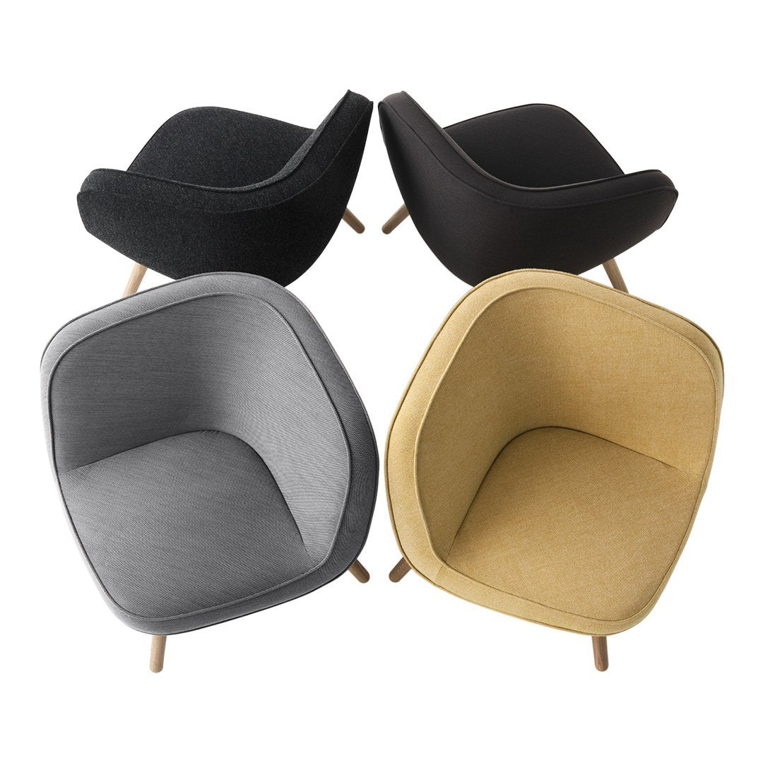 Four modern chairs displayed in black, gray, and mustard yellow upholstery with minimalist design and wooden legs.