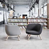 Modern chairs in gray and black upholstery with light wooden legs, featuring smooth, curved designs.