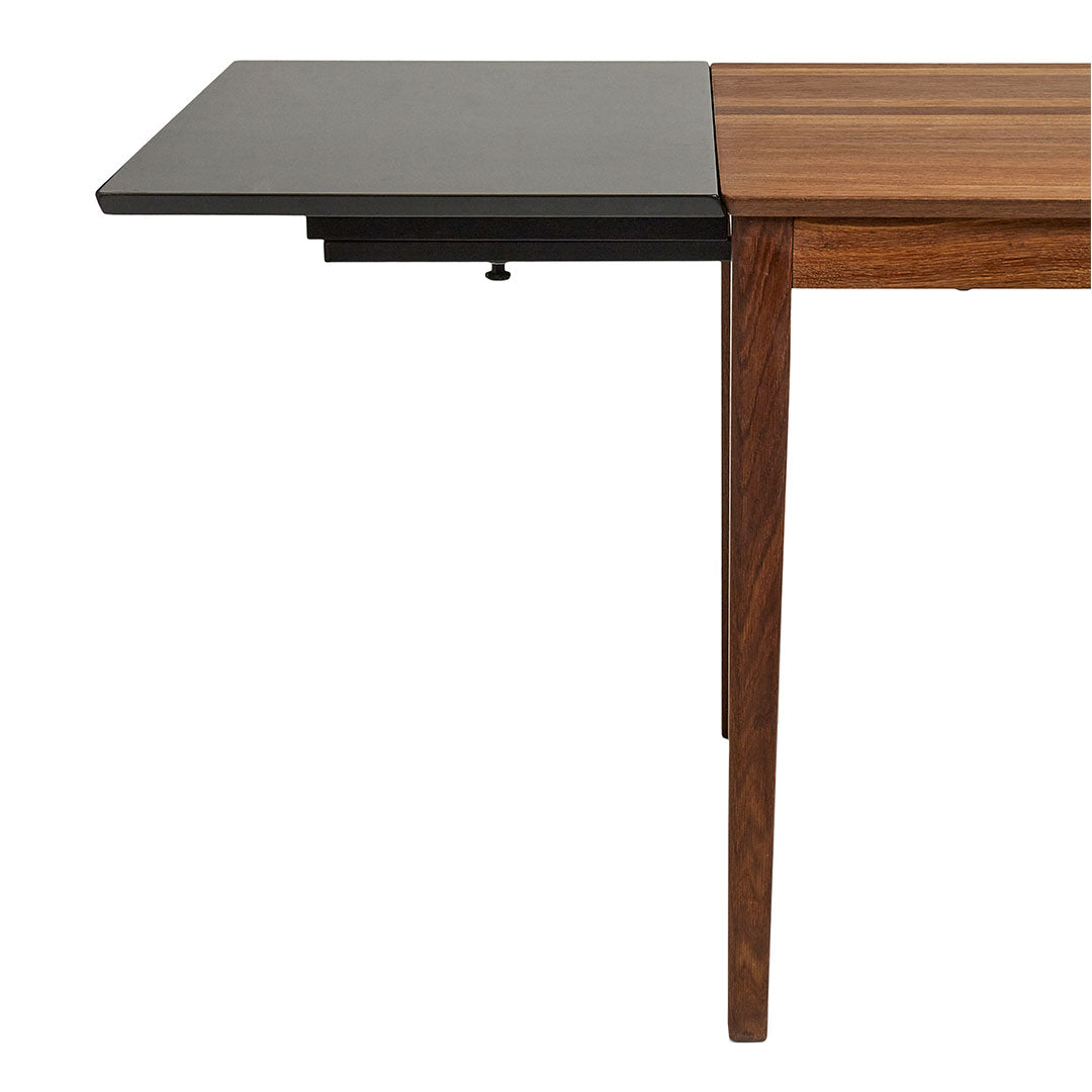 Wooden dining table with a contrasting black extension, featuring a smooth finish and sleek lines in warm brown tones.