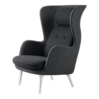 Modern high-back chair in textured dark gray fabric with sleek white legs and subtle button detailing.