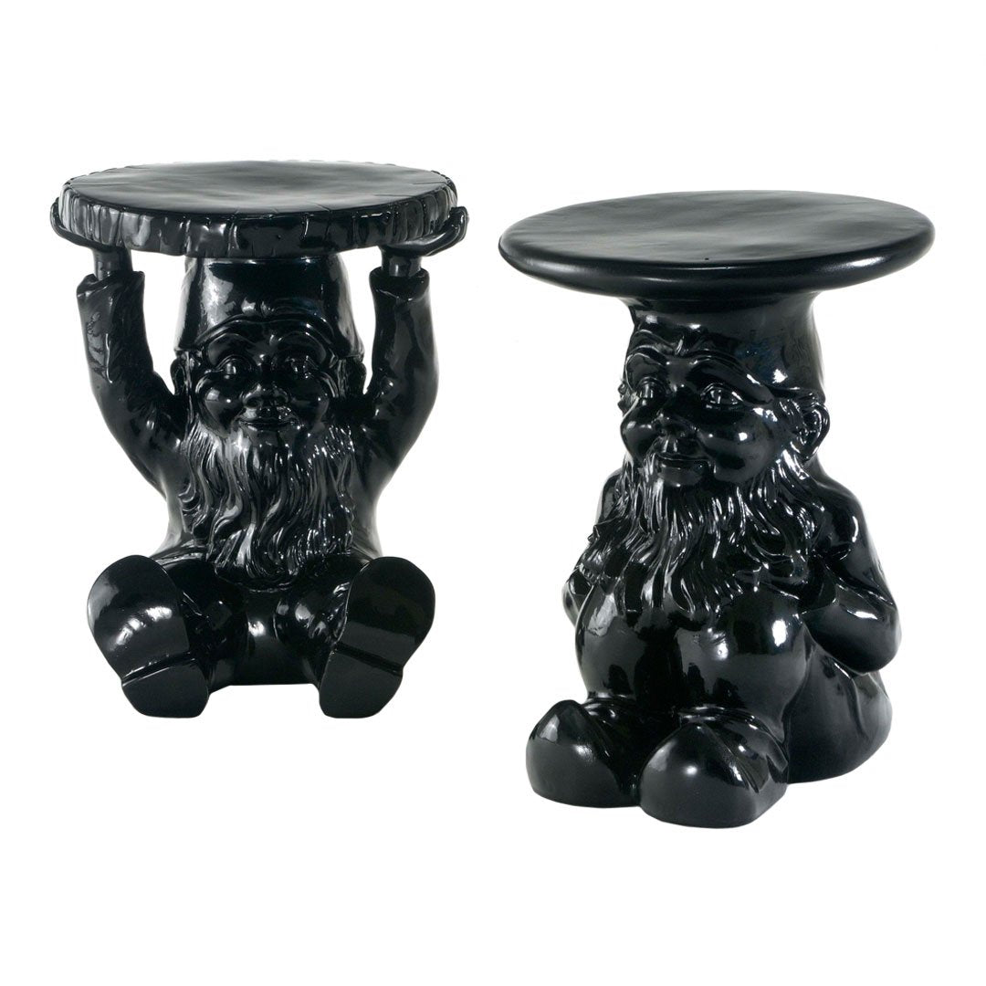 Black ceramic gnome stools with glossy finish and playful design, featuring one gnome holding a tabletop.