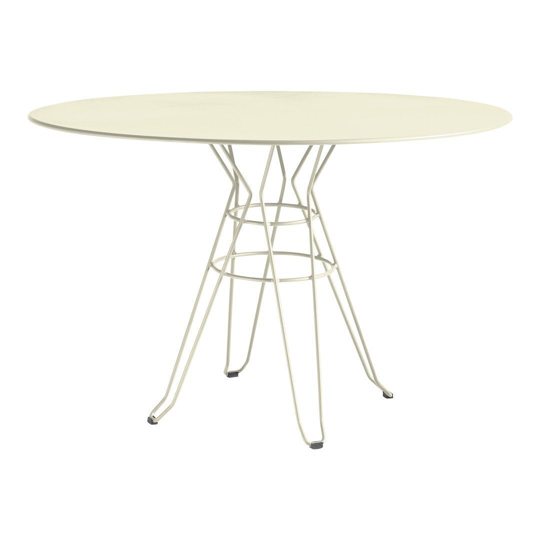 Round cream dining table with a minimalist wire base, perfect for modern decor.
