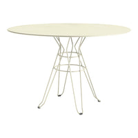 Round cream dining table with a minimalist wire base, perfect for modern decor.