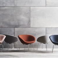 Colorful modern chairs in shades of pink, gray, orange, and navy against a sleek gray wall. Stylish and contemporary design.