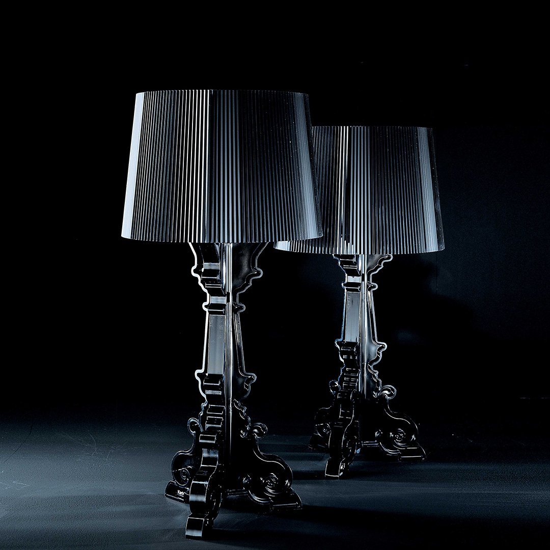 Two elegant black lamps with pleated grey shades, set against a dark backdrop, showcasing sleek lines and sophisticated design.