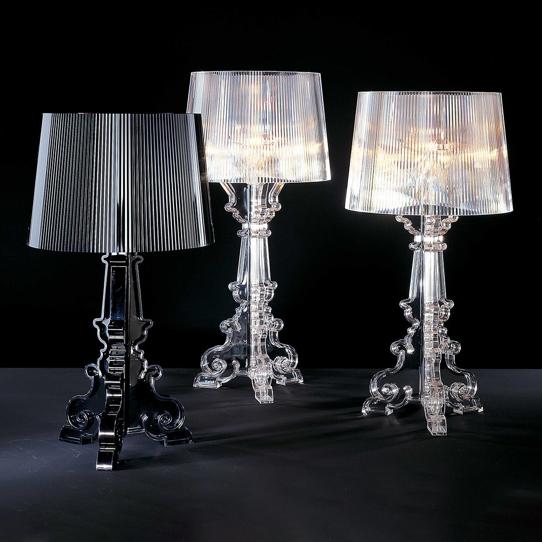 Three stylish lamps: one black, one transparent, and one iridescent, featuring elegant bases with intricate patterns.