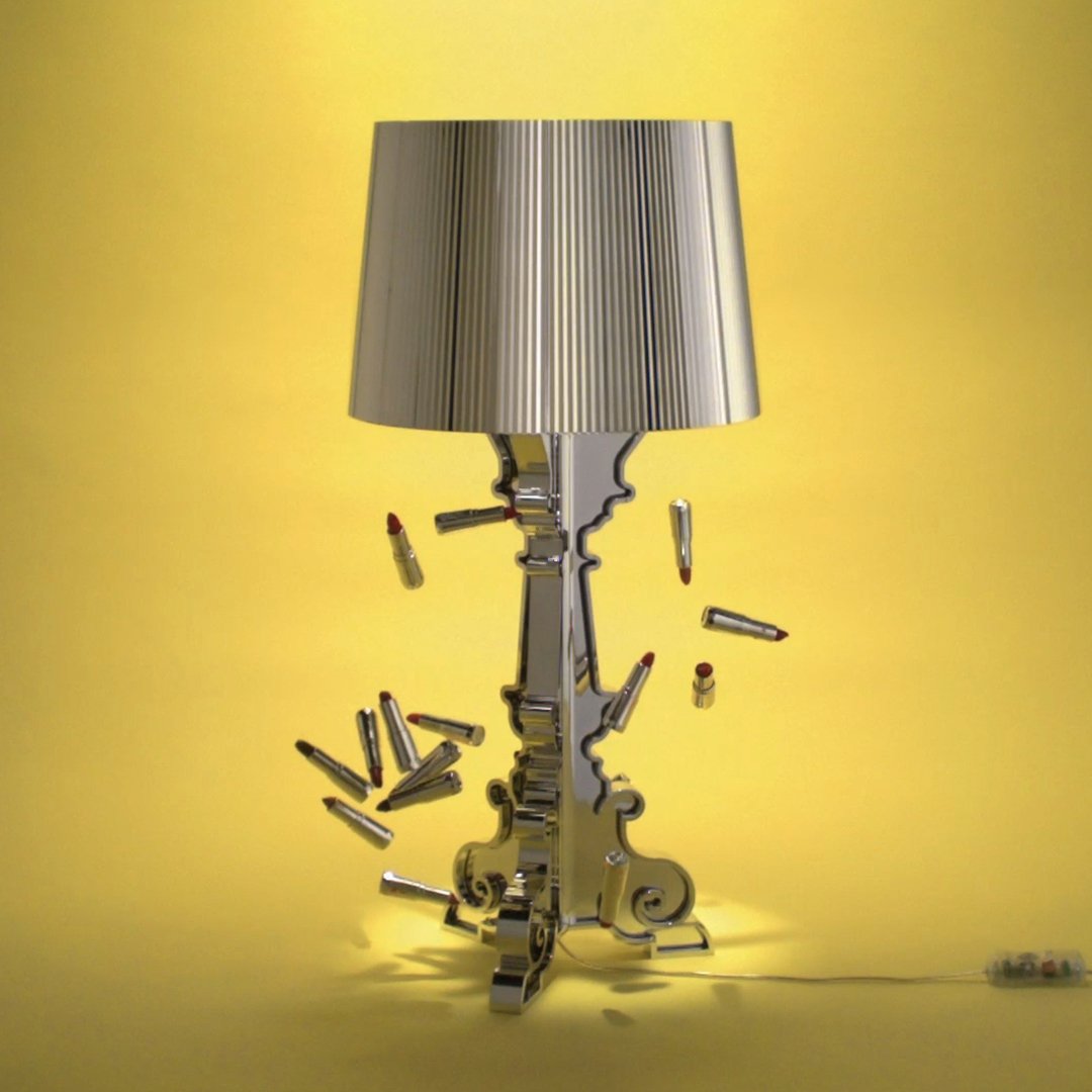 Silver lamp with a pleated shade on a vibrant yellow background, featuring bullet accents for a unique look.