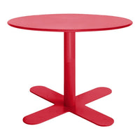 Round red table with a smooth, glossy finish and a minimalist design featuring a cross-shaped base.