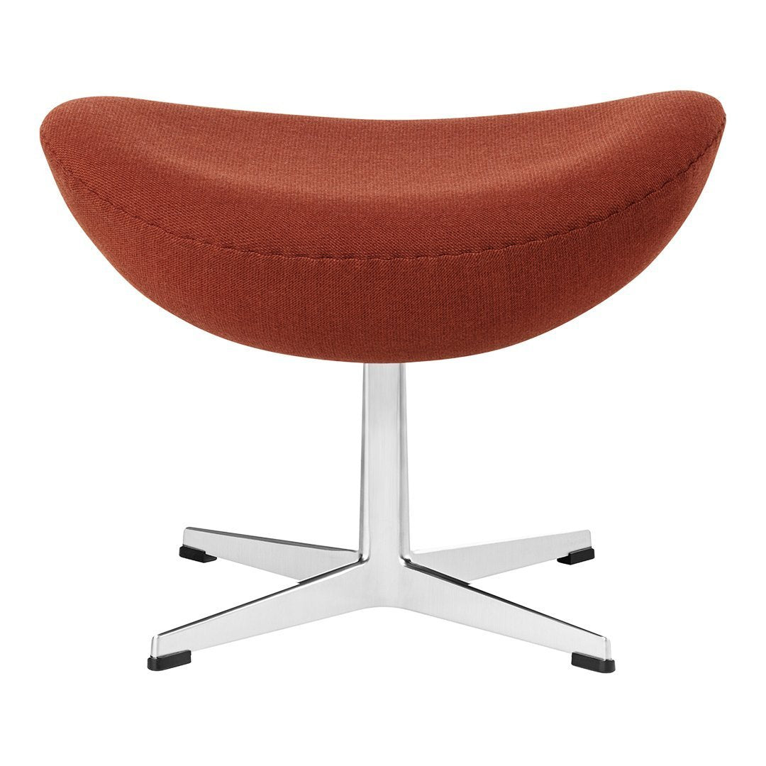 Rust-colored upholstered stool with a smooth, curved design and a sleek chrome base. Perfect for modern decor.