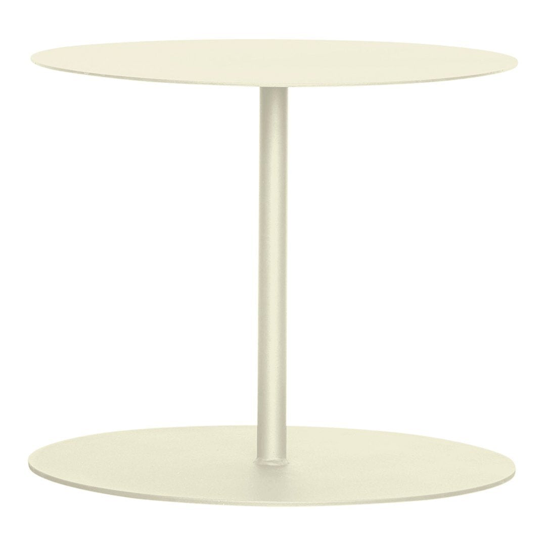 Round cream side table with a minimalist design and smooth surface, featuring a simple metal pole and base.