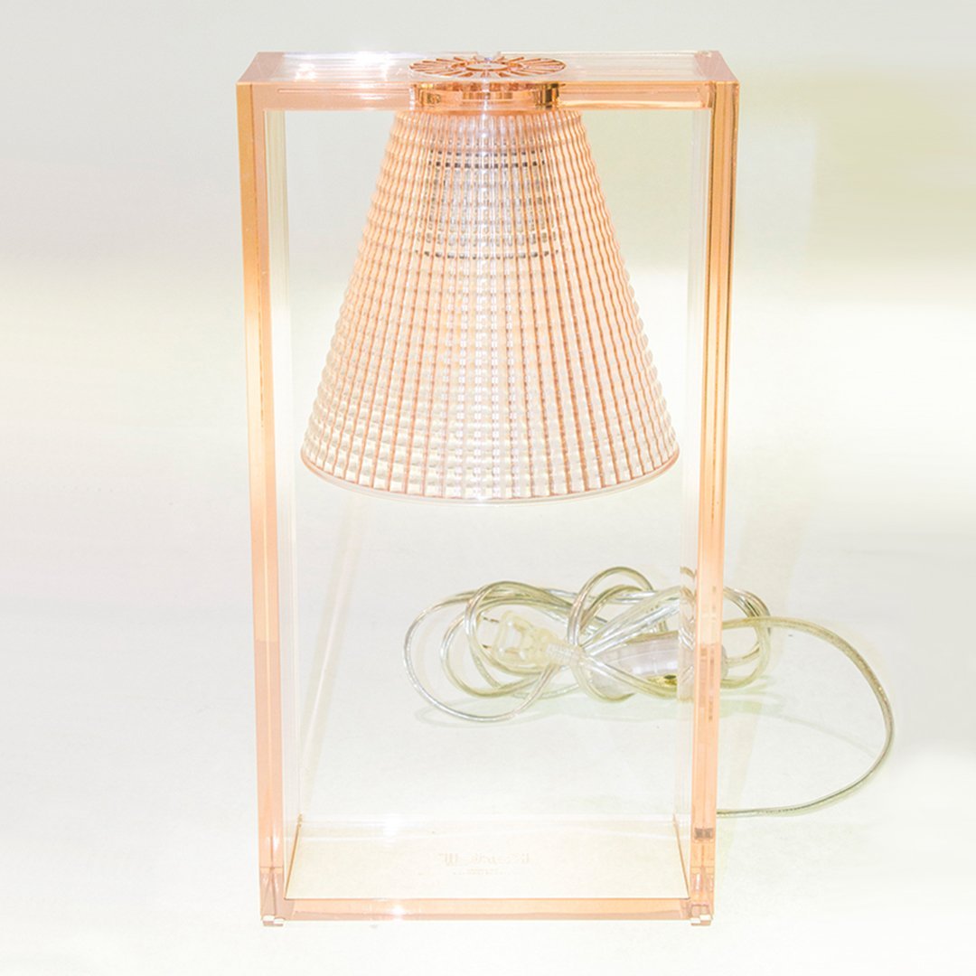 "Transparent peach lamp with a grid-patterned shade and clear base, perfect for modern decor."
