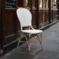 Black and white herringbone pattern chair with woven details, set against a rustic wooden backdrop.