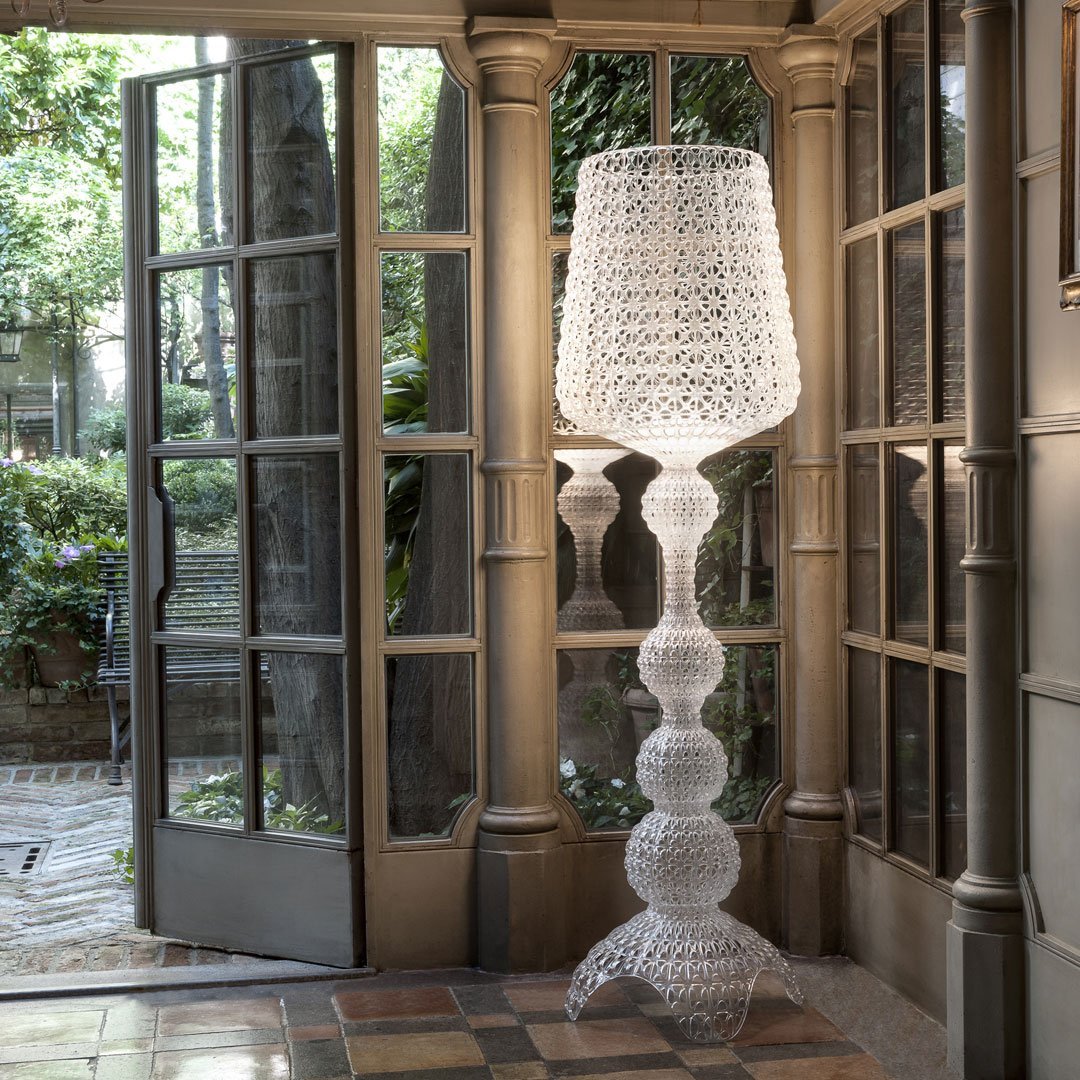 Clear, textured glass floor lamp with a geometric pattern, enhancing elegant decor in natural light.