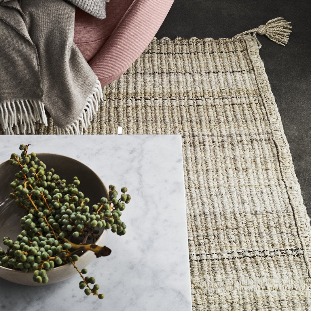 Textured cream and beige woven rug with subtle fringes, featuring a modern, natural pattern. Perfect for cozy interiors.