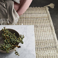 Textured cream and beige woven rug with subtle fringes, featuring a modern, natural pattern. Perfect for cozy interiors.