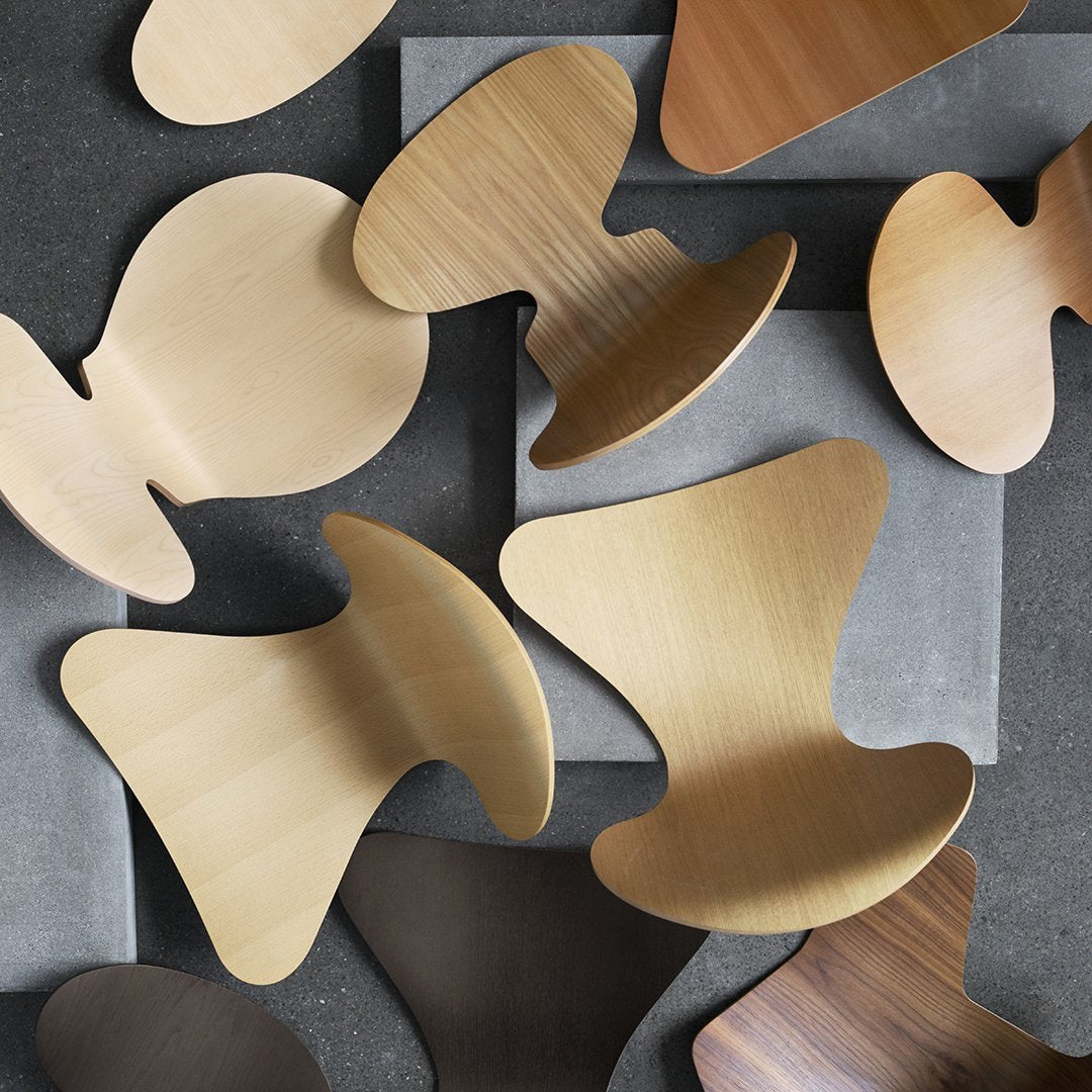Assorted wooden shapes in gold, brown, and light beige, layered over a gray background with smooth textures.