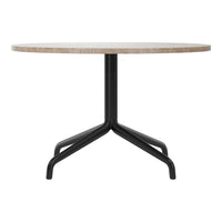 Round table with a beige stone top and sleek black metal base, showcasing a minimalist design.