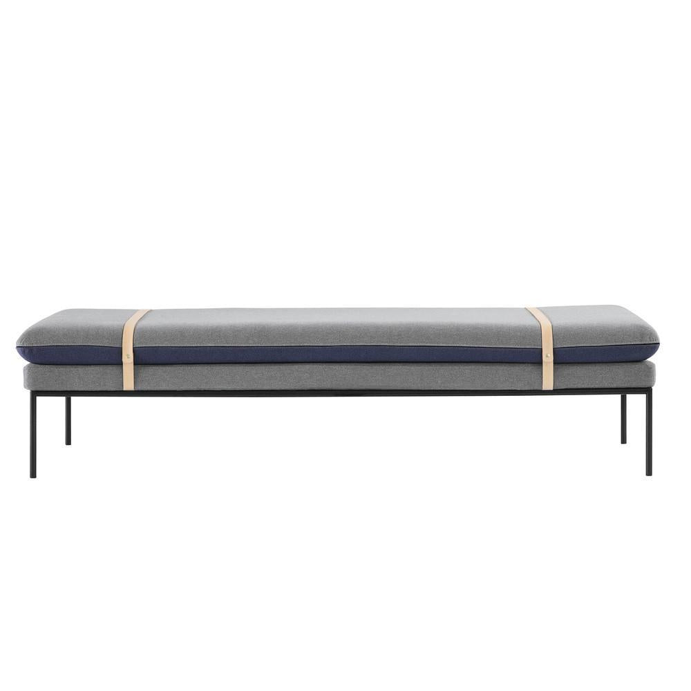 Gray and navy upholstered bench with a minimalist black metal frame and natural wood accents. Modern design.